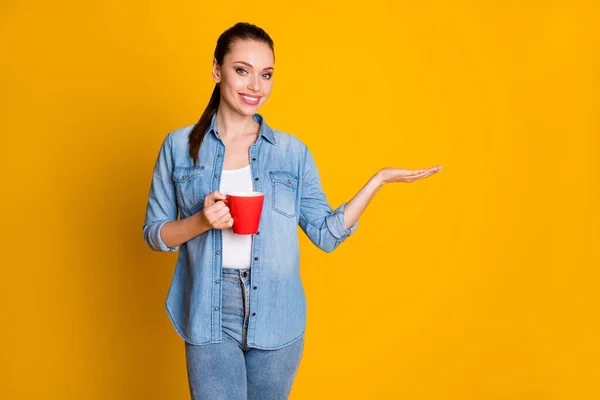 Photo of positive confident girl promoter hold hand display option hirdetések promo ital csésze latte viselet jó megjelenés ruhák elszigetelt felett élénk színű háttér — Stock Fotó