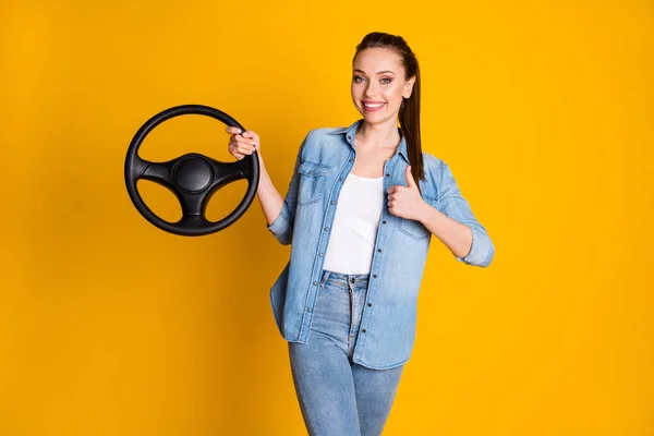 Foto van positieve meisje promotor houden stuurwiel raden nieuwe auto product reclame slijtage denim jeans shirt geïsoleerd over heldere glans kleur achtergrond — Stockfoto