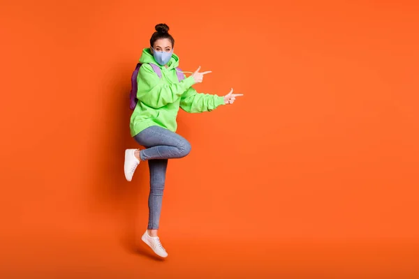 Foto de comprimento total do modelo de estudante dedos diretos espaço vazio jeans pulôver tênis isolado no fundo cor de laranja — Fotografia de Stock