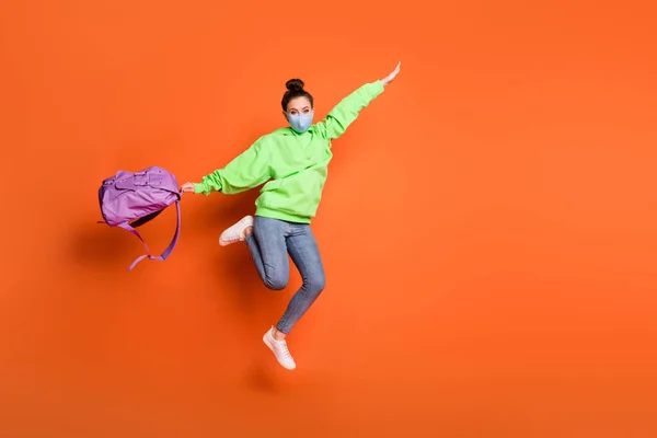 Foto de cuerpo completo de la joven dama salto brazos vuelo bolsa de espera desgaste suéter aislado sobre fondo de color naranja — Foto de Stock