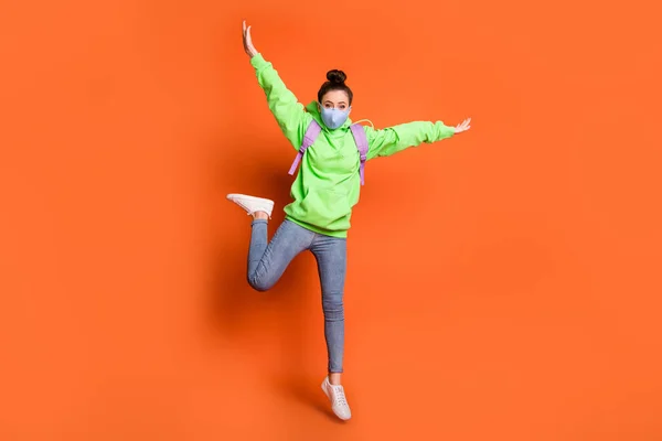 Volledige grootte foto van tevreden persoon spring handen vlucht dragen groene pullover rugzak geïsoleerd op oranje kleur achtergrond — Stockfoto