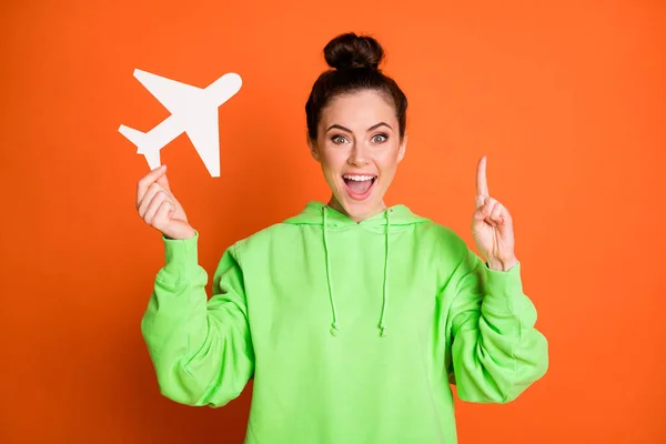 Foto van slimme dame gekleed groene sweater met vinger lege ruimte met papier vliegtuig geïsoleerde heldere oranje kleur achtergrond — Stockfoto