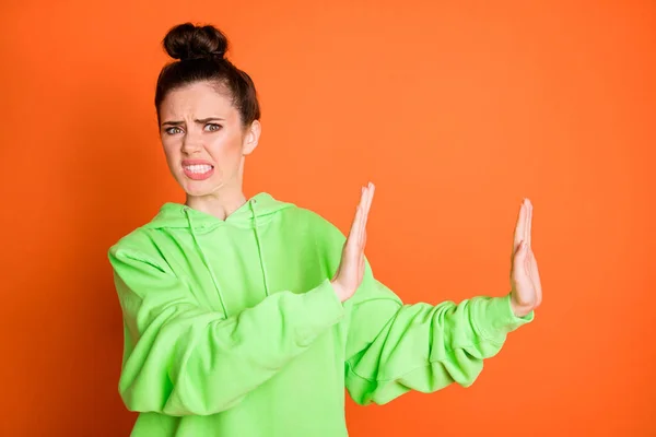 Foto de señora joven disgustado vestido sudadera verde que muestra stop gesto aislado de color naranja brillante fondo —  Fotos de Stock