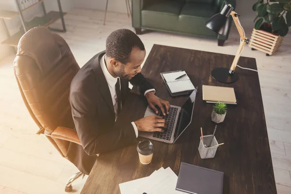 Profilfoto von hübschen dunkelhäutigen Geschäftsmann Kerl Notizbuch Tisch plaudernde Kollegen lesen Corporate Report Versicherungsvertreter tragen Anzug sitzen Stuhl modernes Interieur Büro drinnen — Stockfoto