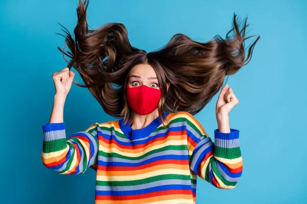 Foto von entzückten Mädchen in roter medizinischer Maske heben die Fäuste genießen genießen covid Stop-Wear-Stil stilvolle trendige Pullover Frisur fliegen isoliert über blauem Hintergrund — Stockfoto