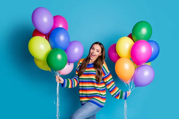 Foto av uppriktig nöjd söt flicka hålla många ballonger njuta av fest fest fest bära bra utseende humör kläder isolerad över blå färg bakgrund — Stockfoto
