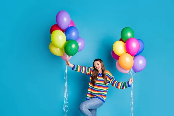 Foto de menina bonita encantadora sentir prazer fechar os olhos segurar muitos balões usar roupas de bom humor olhar isolado sobre fundo de cor azul — Fotografia de Stock