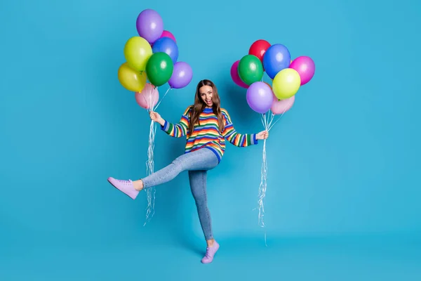 Foto de tamaño completo de la chica emocionada energética celebrar muchos globos que recibe fiesta cumpleaños celebración fiesta levantar la pierna desgaste buen aspecto ropa de humor aislado color azul fondo — Foto de Stock