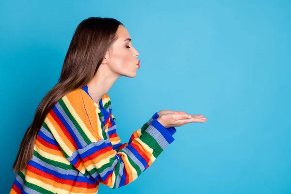 Profilseite Foto von flirty charmante Mädchen halten Hand senden Luftkuss Kopierraum tragen Wintersaison Pullover isoliert über blauem Hintergrund — Stockfoto