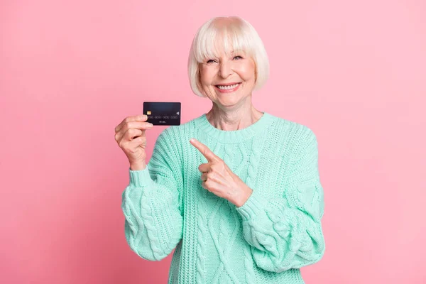 Foto-Porträt der Rentnerin blondes Haar zeigt mit dem Finger Plastikkarte lächeln isoliert auf pastellrosa Hintergrund — Stockfoto