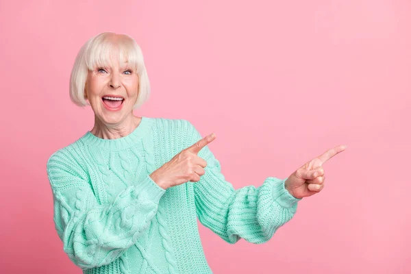 Foto retrato de mulher idosa loira mostrando com os dedos no espaço vazio aconselhando isolado no fundo cor-de-rosa pastel — Fotografia de Stock