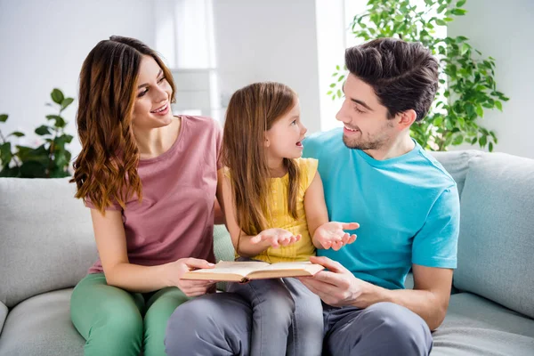 Photo of three people sit couch little kid read book story tell her parents mommy daddy in house indoors — Stock Photo, Image