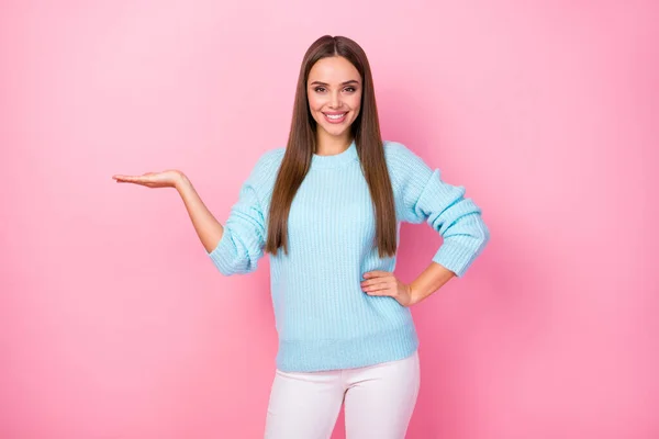 Foto de atractiva señora bonita gerente mantenga abierto brazo novedad producto bajo precio de compra desgaste de punto azul jersey blanco pantalones aislados pastel rosa color fondo — Foto de Stock