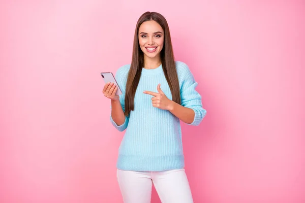 Foto de senhora gerente bonita segurar telefone dedo direto aconselhando qualidade de interface legal novo modelo gadget desgaste malha camisola calças brancas isolado cor rosa fundo — Fotografia de Stock