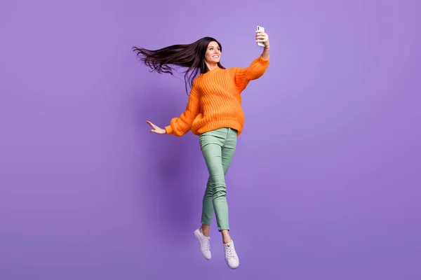 Фотографія повного розміру тіла стрибаючої балерини, посміхаючись, приймаючи селфі на смартфон ізольовано на яскраво-фіолетовому кольоровому фоні — стокове фото