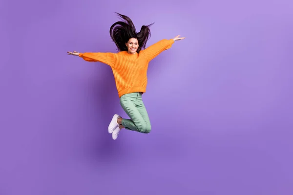 Longitud completa tamaño del cuerpo foto de la niña saltando manteniendo las manos como alas juguetón aislado sobre fondo de color púrpura brillante —  Fotos de Stock