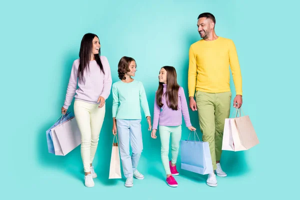 Retrato fotográfico de toda la familia con niños pequeños sosteniendo bolsas aisladas sobre fondo de color verde azulado — Foto de Stock