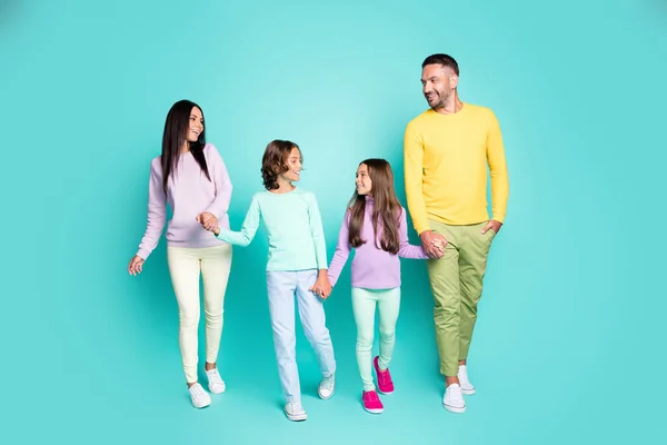 Retrato fotográfico de una gran familia con niños pequeños caminando tomados de las manos aislados sobre un fondo vivo de color turquesa — Foto de Stock