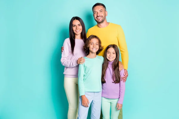 Retrato fotográfico de una gran familia con niños pequeños abrazándose aislados sobre un fondo vivo de color cian — Foto de Stock