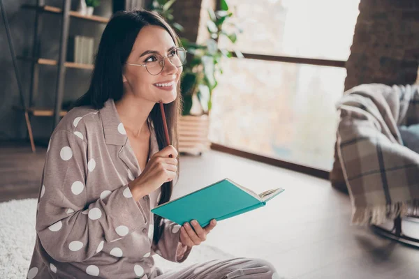 Foto de dulce chica optimista sentarse escribir cuaderno mirar espacio vacío gafas de desgaste pijama en casa — Foto de Stock