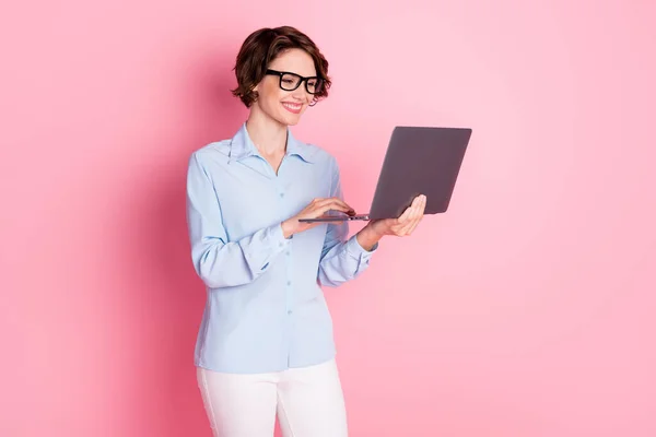 Porträtt av henne hon trevlig attraktiv vacker smart smart fokuserad glad glad glad brunhårig flicka anställd håller i händerna laptop arbetar avlägset isolerad rosa pastell färg bakgrund — Stockfoto