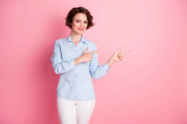 Foto de atractiva encantadora señora bonita dedos directos lado espacio vacío Mostrar venta descuento pancarta shopper desgaste azul oficina camisa pantalones blancos aislado rosa pastel color fondo —  Fotos de Stock