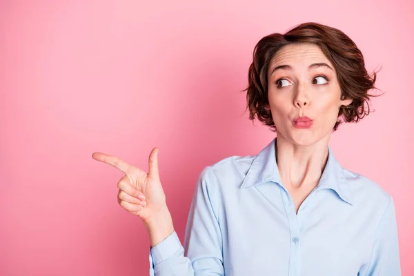 Foto van aantrekkelijke dame sale manager directe vinger kijken geïnteresseerd kant lege ruimte tonen nieuwigheid winkelen banner geschokt slijtage blauw kantoor shirt geïsoleerde roze pastel kleur achtergrond — Stockfoto