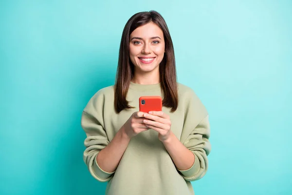 Fénykép portré mosolygós nő kezében telefon két kézzel elszigetelt élénk varangy színű háttér — Stock Fotó