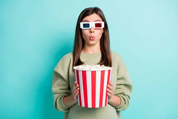 Photo portrait of shocked woman holding large popcorn bucket in two hands wearing 3d glasses isolated on vivid cyan colored background — Stock Photo, Image