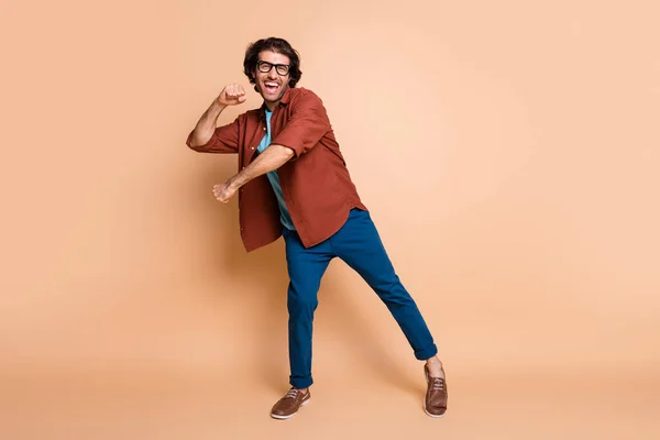 Ganzes Foto von Kerl Tanz offenen Mund Look Kamera tragen Brille braun T-Shirt Hose Schuhe isoliert beige Farbe Hintergrund — Stockfoto