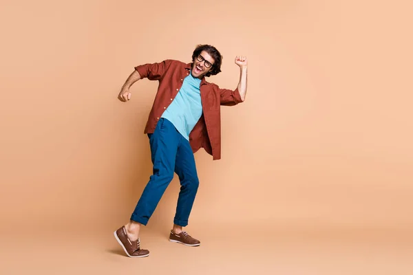 Ganzes Profil Foto von Kerl Tanz offenen Mund tragen Brille braun T-Shirt Hose Schuhe isoliert beige Farbe Hintergrund — Stockfoto