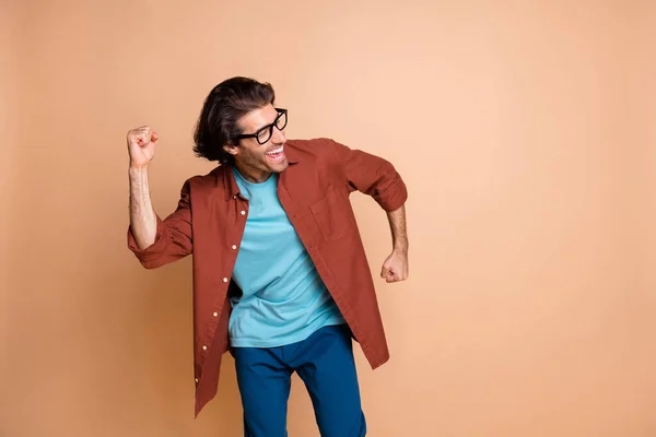 Çılgın genç adamın dans ederken çekilmiş fotoğrafları boş uzay giysisi gözlükleri kahverengi tişört izole edilmiş bej arka plan — Stok fotoğraf