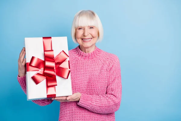 Pastel mavi arka planda iki el izole edilmiş hediye kutusunu tutan yaşlı kadının fotoğrafı. — Stok fotoğraf