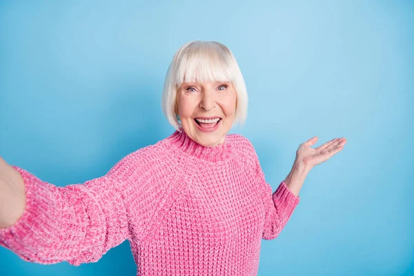 Foto portrét chladné staré ženy, přičemž selfie představuje držení prázdný prostor v ruce izolované na pastelové modré barevné pozadí — Stock fotografie