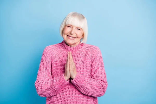 Foto portrét staré ženy držící ruce k sobě v modlitbě izolované na pastelově modrém pozadí — Stock fotografie