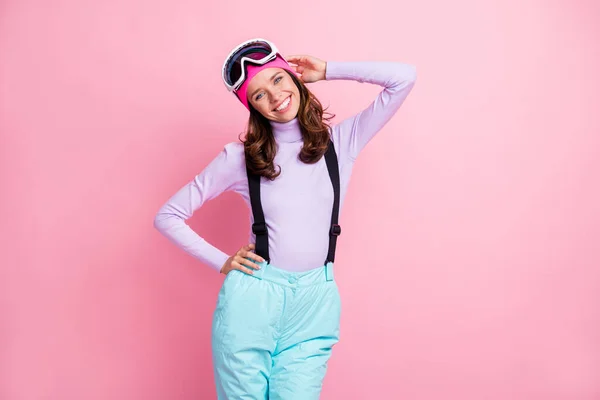 可愛い甘い女性のスノーボーダーの写真は、紫色のプルオーバーヘッドウェア眼鏡を着用してください腕腰の分離ピンク色の背景を持っています — ストック写真
