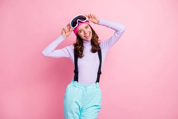 魅力的な甘い女性のスキーヤーの写真は、バイオレットセーター腕ゴーグルマスクを身に着けています残りの隔離されたピンク色の背景 — ストック写真