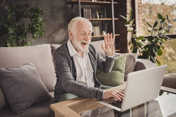 Photo of funny pensioner wear grey cardigan sitting looking modern gadget have video call indoors house flat — Stock Photo, Image