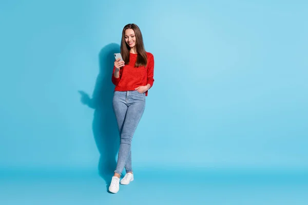 Foto de longitud completa de niña alegre positivo uso smartphone desgaste suéter aislado sobre fondo de color azul —  Fotos de Stock