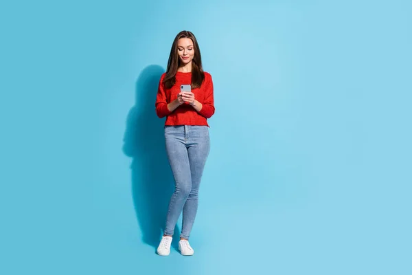 Foto em tamanho completo de menina encantadora usar o smartphone usar jumper isolado sobre fundo de cor azul — Fotografia de Stock