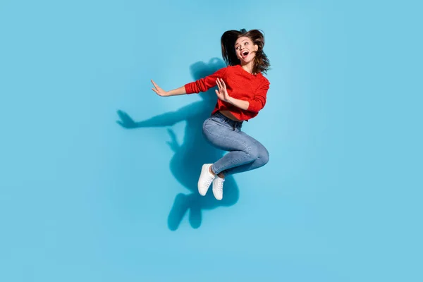 공중 파티에서 점프하는 펑키 아줌마의 전체 길이 사진빨간 펄럭 이 스니커즈 청바지 고립 된 푸른 색상 배경 — 스톡 사진