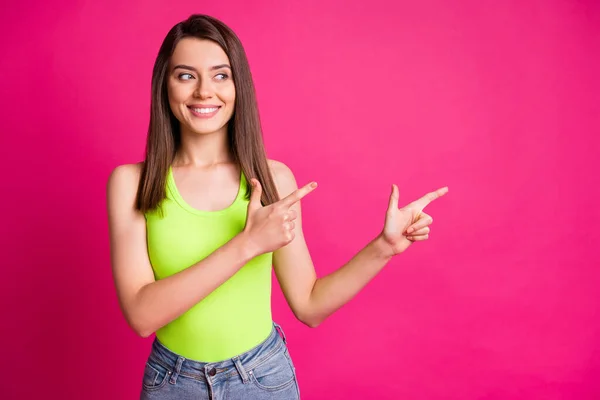 Foto van geïnteresseerd jong meisje geven wijsvinger kijken lege ruimte dragen groene top geïsoleerde levendige roze kleur achtergrond — Stockfoto