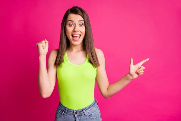 Фото фанкі божевільної дівчини прямий палець порожній простір підняти кулак відкритим ротом носити зелений верх ізольований яскраво-рожевий кольоровий фон — стокове фото