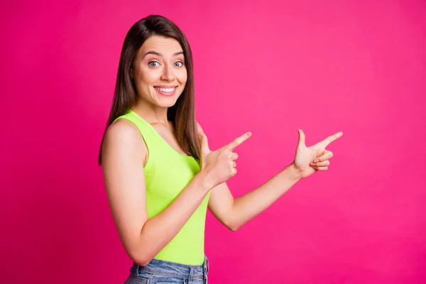 Foto di eccitato giovane ragazza indicano dita spazio vuoto irradiante sorriso usura verde singoletto isolato vivido colore rosa sfondo — Foto Stock