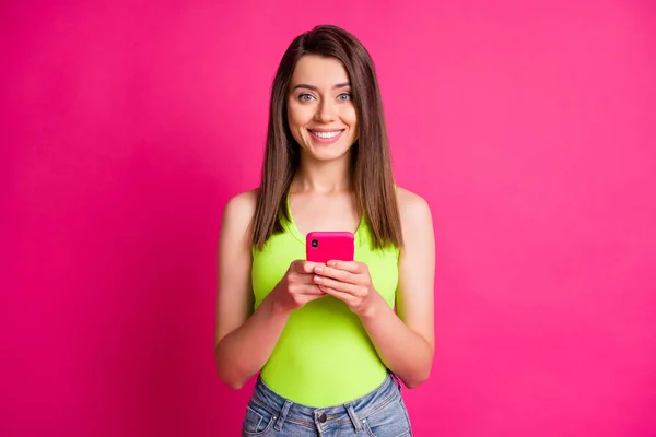 Фото веселої красивої леді тримає телефонну зубну посмішку в зеленому верхньому ізольованому яскравому рожевому кольоровому фоні — стокове фото