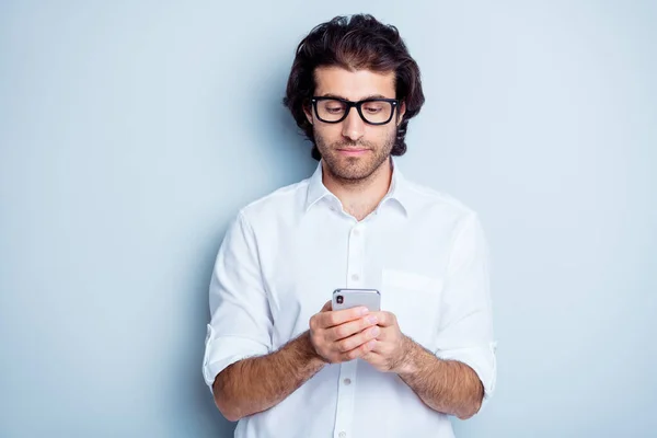 Фотографічний портрет концентрованої людини, що тримає телефон у двох руках ізольовано на прозорому білому тлі — стокове фото