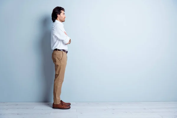 Foto portret full side body view van zelfverzekerde man op zoek naar lege ruimte met gevouwen armen geïsoleerd op helder wit gekleurde achtergrond — Stockfoto