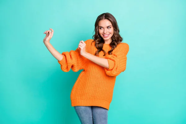 Foto de una joven bastante sonriente mujer bailando look copyspace desgaste suéter de punto naranja aislado sobre fondo de color turquesa —  Fotos de Stock