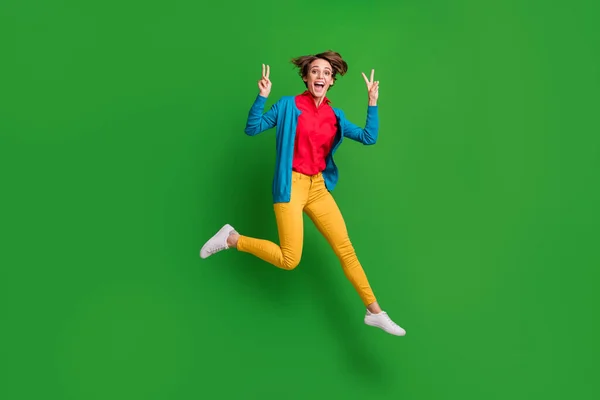 Pleine longueur taille du corps photo de joyeuse fille heureuse sautant montrant v-signe les deux mains isolées sur fond de couleur vert vif — Photo