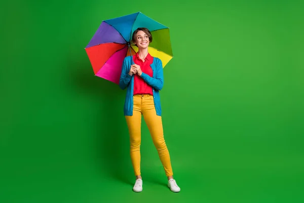 Tamanho do corpo de comprimento total foto da menina com cabelo bob mantendo guarda-chuva colorido olhando espaço em branco isolado no fundo de cor verde vibrante — Fotografia de Stock